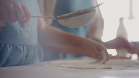 little-girl-is-helping-mother-during-cooking-pie-or-bun-daughter-is-kneading-dough-and-pouring-flour-closeup